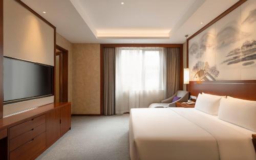 a hotel room with a bed and a flat screen tv at Atour Hotel Wangfujing Ave Xinjiekou Nanjing in Nanjing