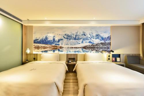 two beds in a hotel room with a painting on the wall at Atour Hotel Capital Airport Beijing in Beijing