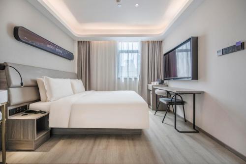 a hotel room with a bed and a desk at Atour Hotel Zhuhai Gongbei Port Fuhuali CBD in Zhuhai