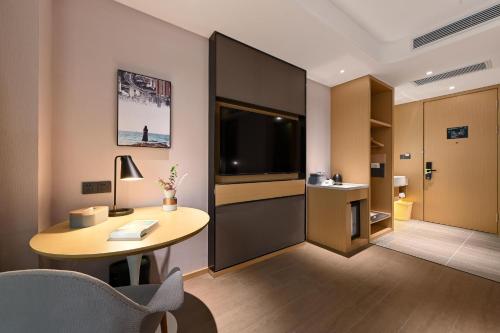 a hotel room with a desk and a television at Atour Hotel Changchun Automobile Development Zone in Changchun