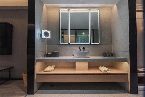 a bathroom with a sink and a mirror at Atour S Hotel Chongqing Jiefangbei Hongyadong Riverview in Chongqing