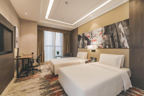 a hotel room with two beds and a desk at Atour Hotel Guanyin Bridge Chongqing in Chongqing