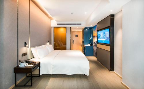 a hotel room with a large bed and a television at Atour Hotel Shenzhen Baoan International Airport in Bao'an
