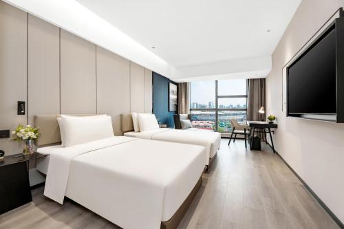 a hotel room with two beds and a flat screen tv at Atour Hotel Changsha Pedestrian Street IFC Center in Changsha