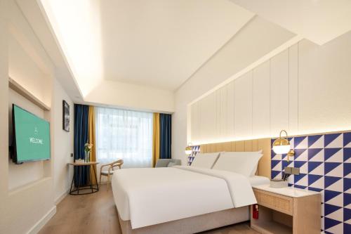 Atour X Hotel Shenzhen Airport Bao'an Yitian Plaza في باوان: غرفة فندق بسرير وتلفزيون