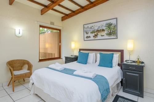 a bedroom with a large bed with blue pillows at San Lameer Villa 2026 - 1 Bedroom Classic - 2 pax - San Lameer Rental Agency in Southbroom