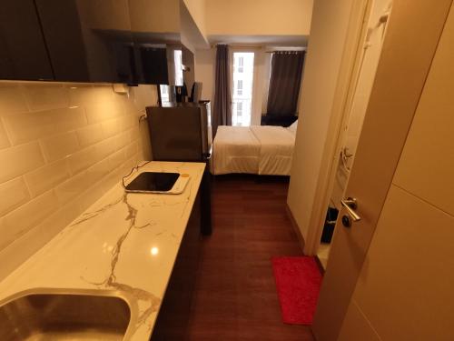 a bathroom with a counter and a room with a bed at Apartemen Tokyo Riverside @pik 2 Tower Dotonbori Lt 15 