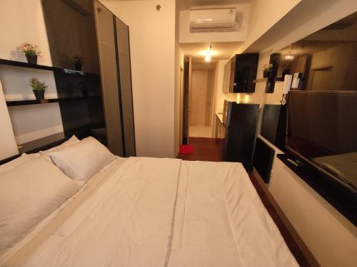 a bedroom with a large white bed in a room at Apartemen Tokyo Riverside @pik 2 Tower Dotonbori Lt 15 