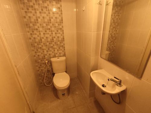 a small bathroom with a toilet and a sink at Apartemen Tokyo Riverside @pik 2 Tower Dotonbori Lt 15 