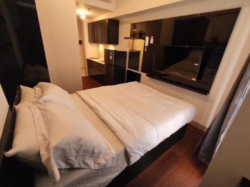 a bedroom with a bed and a flat screen tv at Apartemen Tokyo Riverside @pik 2 Tower Dotonbori Lt 15 