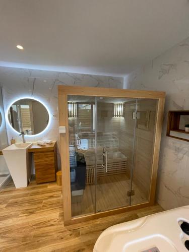 y baño con ducha acristalada y lavamanos. en Luxury spa vallon en Vallon-Pont-dʼArc