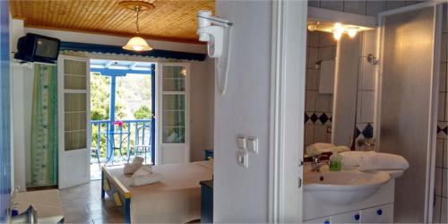 ein Badezimmer mit einem Waschbecken und ein Badezimmer mit einer Badewanne in der Unterkunft Galini Hellenic Hospitality in Patitiri