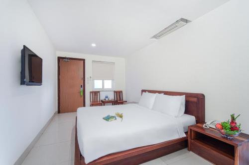 a bedroom with a white bed and a television at Hotel Soco in Da Nang