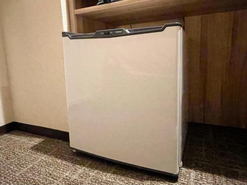 a small refrigerator in a corner of a room at Kusatsu Daiichi Hotel in Kusatsu