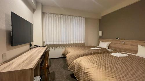 Postel nebo postele na pokoji v ubytování Kusatsu Daiichi Hotel