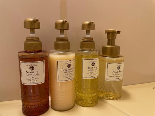 a group of four bottles of oils on a counter at Kusatsu Daiichi Hotel in Kusatsu