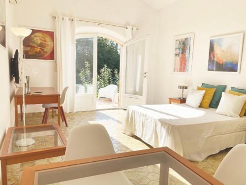 a bedroom with a bed and a table and chairs at Studio 17 - LES SUITES DE ROBINSON - Résidence avec piscine en bord de Siagne, à Mandelieu-La-Napoule in Mandelieu-la-Napoule