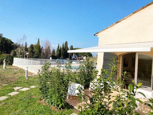 a garden in front of a house with a fence at Studio 17 - LES SUITES DE ROBINSON - Résidence avec piscine en bord de Siagne, à Mandelieu-La-Napoule in Mandelieu-la-Napoule