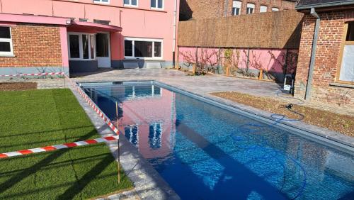 a swimming pool in a yard next to a building at Avant Garde in Watou