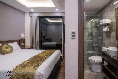 a hotel room with a bed and a shower at 3T Hotel 41 Nguyễn Thái Học- by Bay Luxury in Hanoi