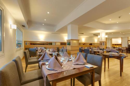 a dining room with tables and chairs in a restaurant at Gran Hotel Los Angeles in Getafe