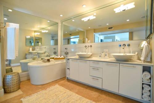 ein Badezimmer mit zwei Waschbecken und einem großen Spiegel in der Unterkunft Villa Naomi - Luxury Design New Home in Miami