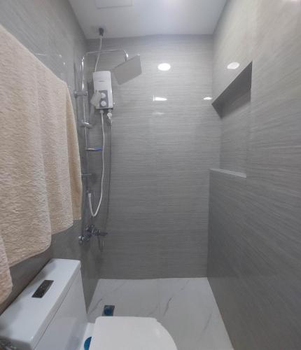 a bathroom with a shower and a white toilet at Victoria Sports Tower Cozy Rooms in Manila