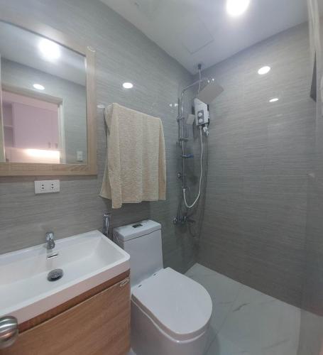 a bathroom with a toilet and a sink and a shower at Victoria Sports Tower Cozy Rooms in Manila