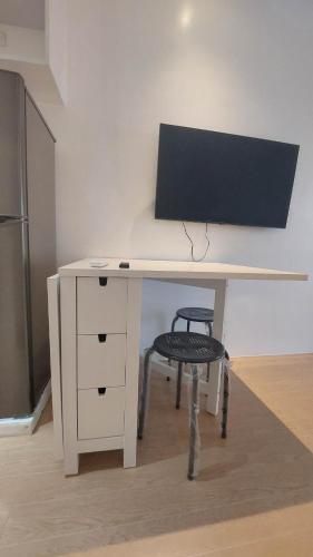 a white desk with a chair next to a refrigerator at Victoria Sports Tower Cozy Rooms in Manila