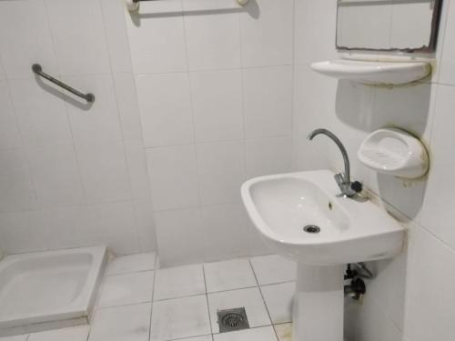 a white bathroom with a sink and a shower at Amman Palace Hotel in Amman