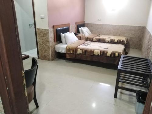 a hotel room with two beds and a table at Amman Palace Hotel in Amman
