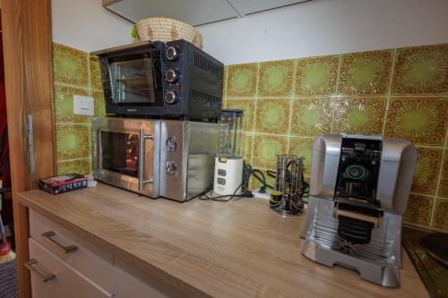 uma cozinha com um balcão, comodidades para preparar café e um micro-ondas em Ferienhaus Hölzl 