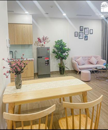 a kitchen with a table with flowers in a room at Capsule Ecopark in HÆ°ng YÃªn
