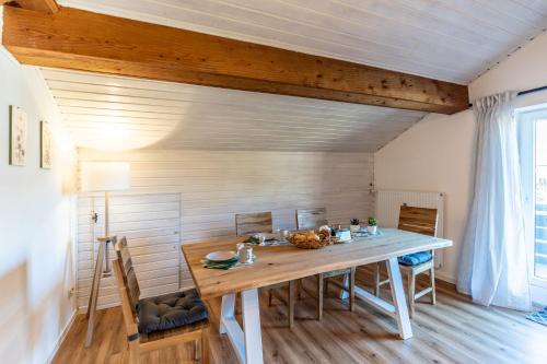 ein Esszimmer mit einem Holztisch und Stühlen in der Unterkunft Freidorf in Rettenberg