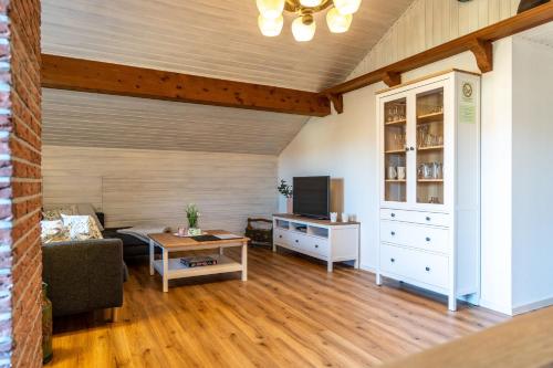 ein Wohnzimmer mit einem Sofa, einem Tisch und einem TV in der Unterkunft Freidorf in Rettenberg