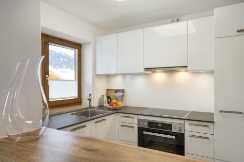 eine Küche mit weißen Schränken und einer hölzernen Arbeitsplatte in der Unterkunft Glückspilz in Obermaiselstein