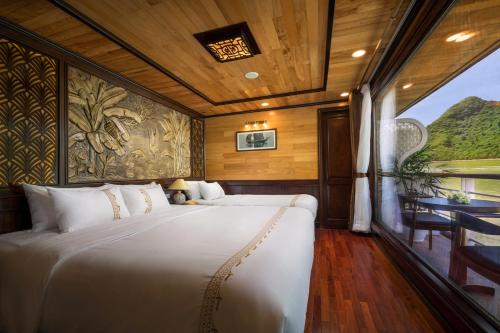 a bedroom with a large bed and a table at V'Spirit Cruise in Ha Long