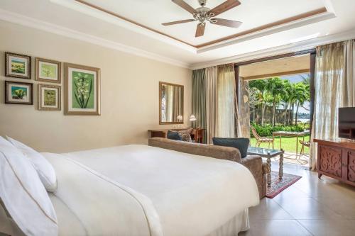 - une chambre avec un grand lit blanc et une porte coulissante en verre dans l'établissement The Westin Turtle Bay Resort & Spa, Mauritius, à Balaclava