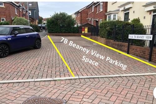 un coche aparcado en un aparcamiento con una plaza de aparcamiento nueva en Beaney View House - Modern, Spacious 4 Bedrooms Ensuites House with Free Wifi and Parkings en Swindon