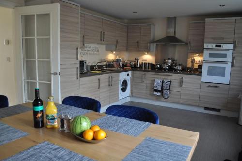 a kitchen with a table with a bowl of fruit on it at Beaney View House - Modern, Spacious 4 Bedrooms Ensuites House with Free Wifi and Parkings in Swindon