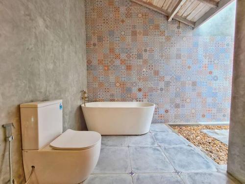 a bathroom with a toilet and a bath tub at Wattala Villa- The Guardian Bungalow in Wattala