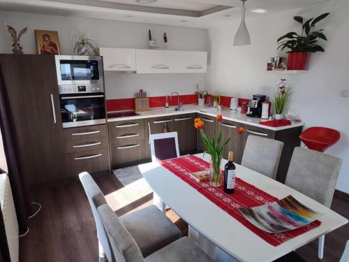 a kitchen with a white table with chairs and a kitchen with a counter at Villa Strashimirovo in Strashimirovo
