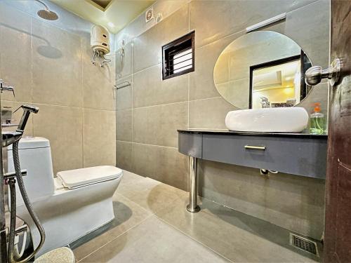 a bathroom with a sink and a toilet and a mirror at Lotus-Explore Kerala 365 in Trivandrum
