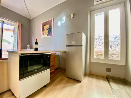 Il comprend une cuisine équipée d'un réfrigérateur en acier inoxydable et une fenêtre. dans l'établissement Lovely & sunny loft heart of Nice with A/C!, à Nice
