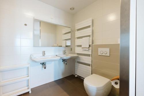 ein Badezimmer mit zwei Waschbecken und einem WC in der Unterkunft Appartement in Zeeland - Kabbelaarsbank 512 - Port Marina Zélande - Ouddorp - With garage - not for companies in Ouddorp