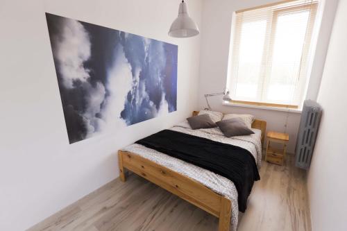 1 dormitorio con 1 cama y una pintura en la pared en Apartament Wały Chrobrego, en Szczecin