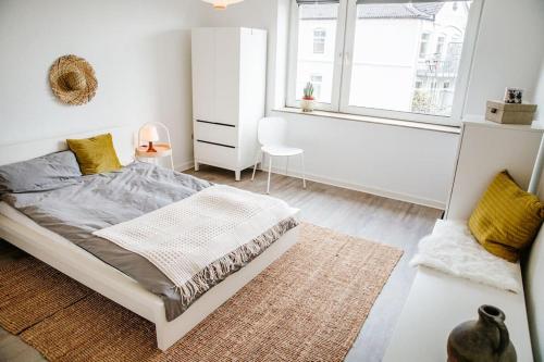 een witte slaapkamer met een bed en een raam bij City-Appartement, Holtenauer Straße mit 24h Check-in in Kiel
