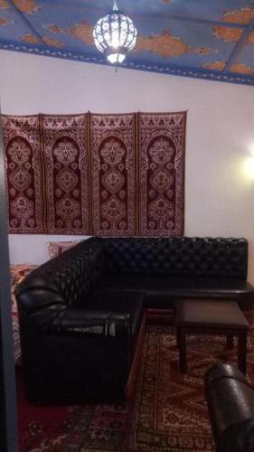 a black leather couch in a room with a ceiling at DAR Casa Plasa Grande CHEFCHAOUEN in Chefchaouene