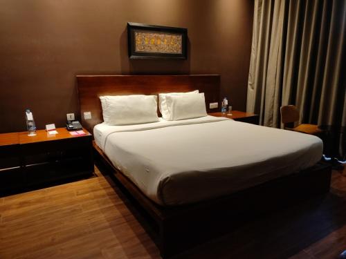 a bedroom with a bed and a wooden headboard at MONTANA VISTA in Siliguri