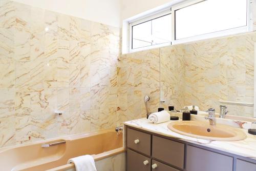 une salle de bain avec une baignoire et un lavabo et une baignoire dans l'établissement 444 Tourny - Localisation exceptionnelle 2 chambres avec ascenseur et Parking, à Bordeaux